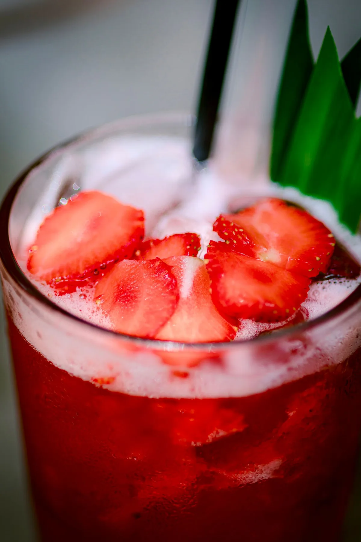 Strawberry Spritz, deep red with fresh strawberry slices